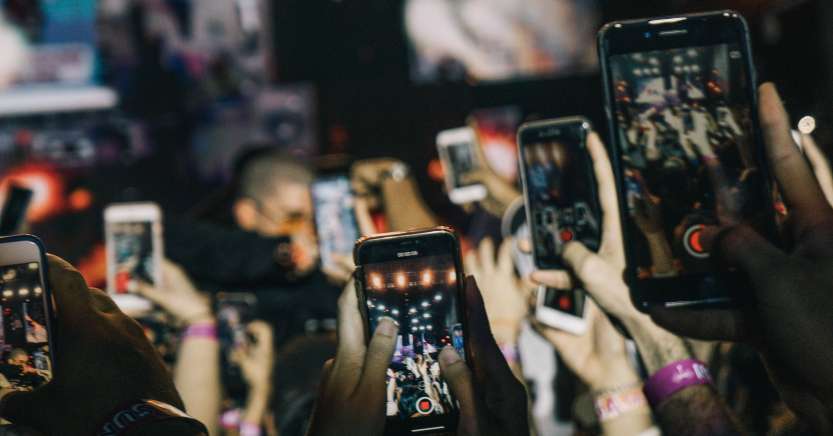 People using their smartphones to take pictures of an event.